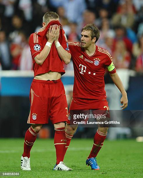 Bastian Schweinsteiger of Bayern Muenchen is comforted by Philipp Lahm after missing to score his penalty in the penalty shoot out during the UEFA...
