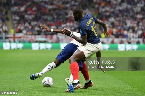 Bukayo Saka of England battles for possession with Dayot Upamecano of France during the FIFA World Cup Qatar 2022 quarter final match between England...