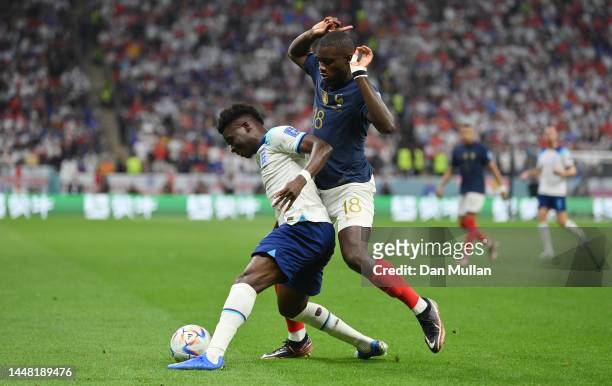 Bukayo Saka of England battles for possession with Dayot Upamecano of France during the FIFA World Cup Qatar 2022 quarter final match between England...