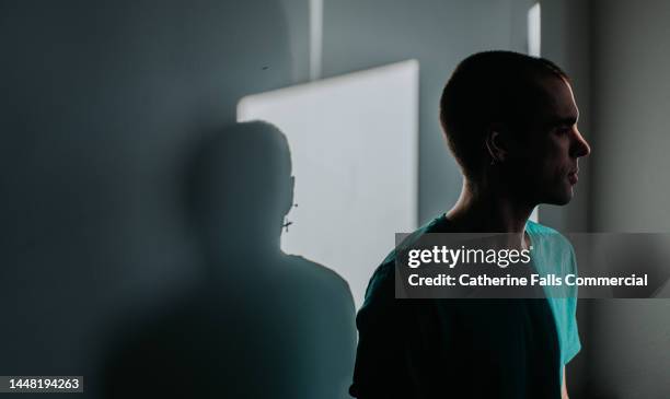 a backlit male is almost completely obscured in shadow. - obscured face ストックフォトと画像