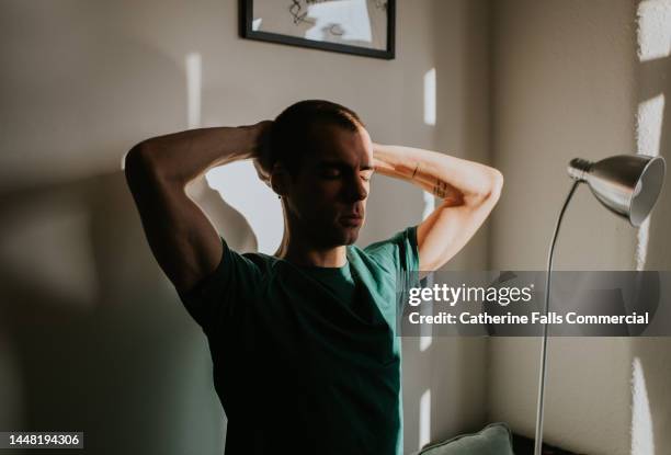 conceptual portrait of a man, obscured in shadow - man doing yoga in the morning stockfoto's en -beelden