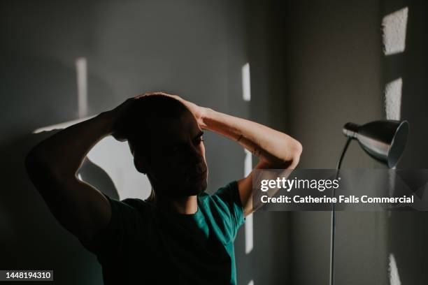 conceptual portrait of a man, obscured in shadow - touching elbows stock pictures, royalty-free photos & images