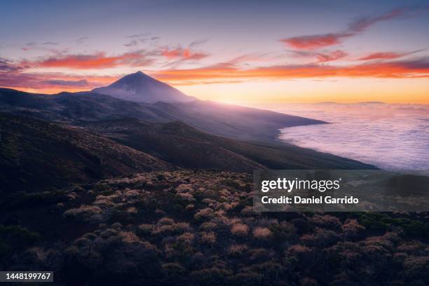sunset in the teide national park next to a sea of clouds, landscape photography - pico de teide stock-fotos und bilder