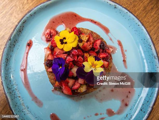 vegan pancake stack, made with banana, oats, flaxseed, almond milk, with a maple syrup and red fruit compote - violales stock pictures, royalty-free photos & images