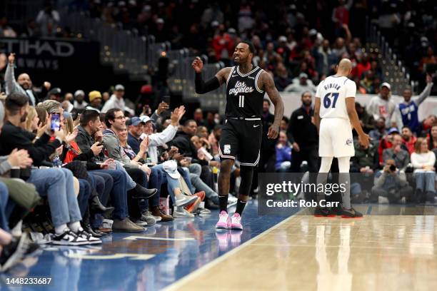 John Wall of the Los Angeles Clippers celebrates after hitting a first half three pointer against the Washington Wizards at Capital One Arena on...