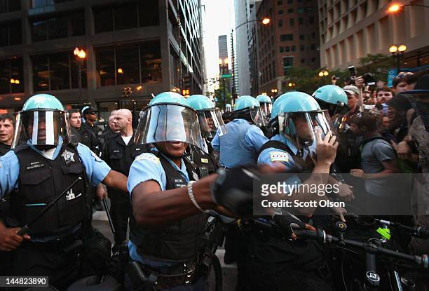 Police swing their batons to try and keep demonstrators from breaking through their lines durijng a march through the downtown streets on May 19,...