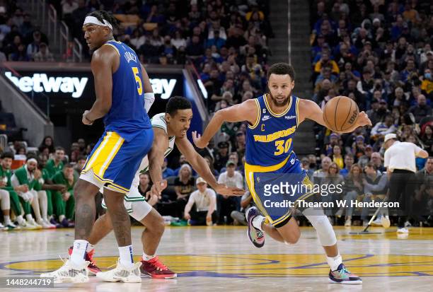Stephen Curry of the Golden State Warriors dribbles around a screen set by Kevon Looney on Malcolm Brogdon of the Boston Celtics during the second...