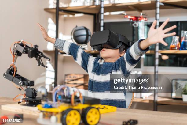 pleasant smart boy testing vr glasses at home - vr goggles business stockfoto's en -beelden