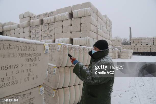 Worker scans QR code before checking the quality of cotton at a cotton enterprise on December 10, 2022 in Urumqi, Xinjiang Uygur Autonomous Region of...