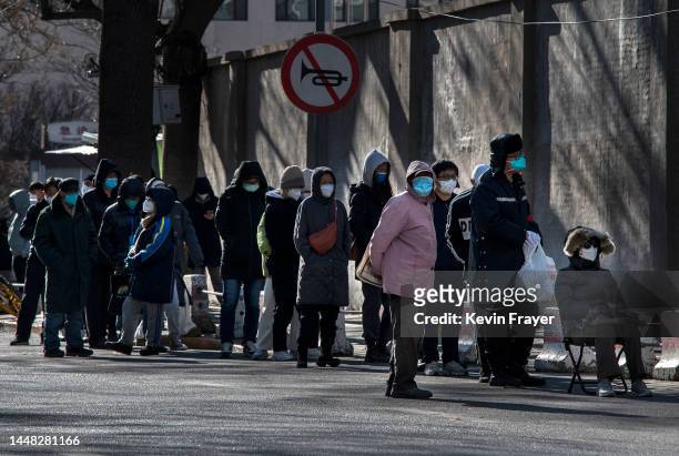 People line up outside a fever clinic at a hospital in the morning on December 11, 2022 in Beijing, China. As part of a 10 point directive, Chinas...