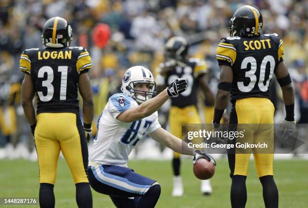 Wide receiver Drew Bennett of the Tennessee Titans signals a first down after catching a pass against defensive backs Mike Logan and Chad Scott of...