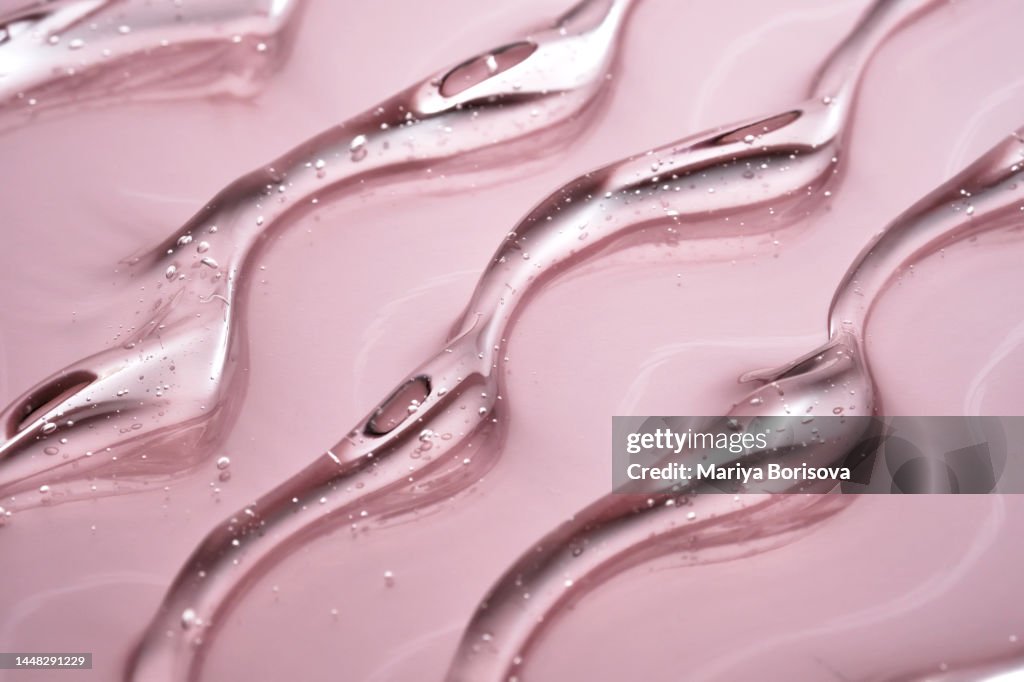 The texture of the cosmetic gel on a pink background.