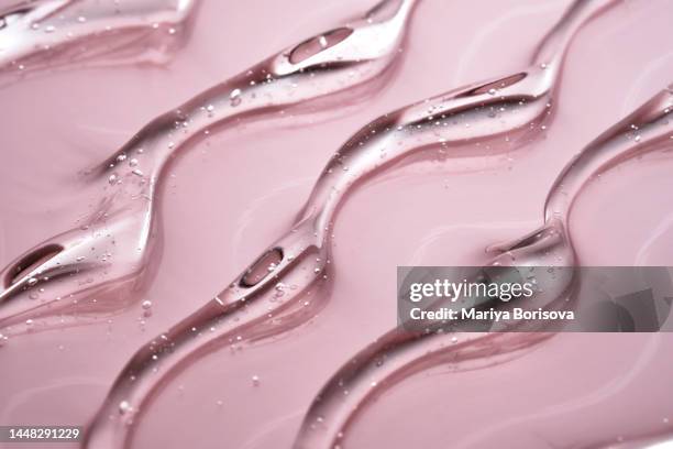 the texture of the cosmetic gel on a pink background. - gel foto e immagini stock