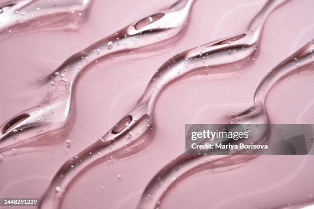 the texture of the cosmetic gel on a pink background. - facial cleanser stockfoto's en -beelden