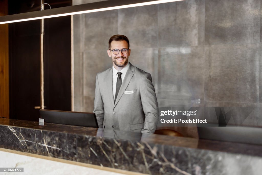 Male Receptionist Looking at Camera