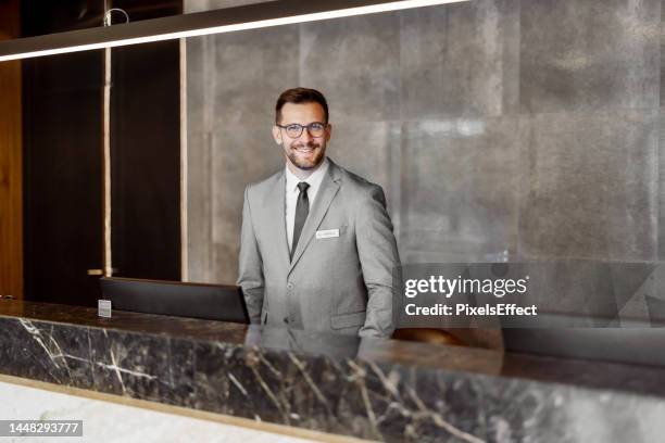 male receptionist looking at camera - checkout 個照片及圖片檔