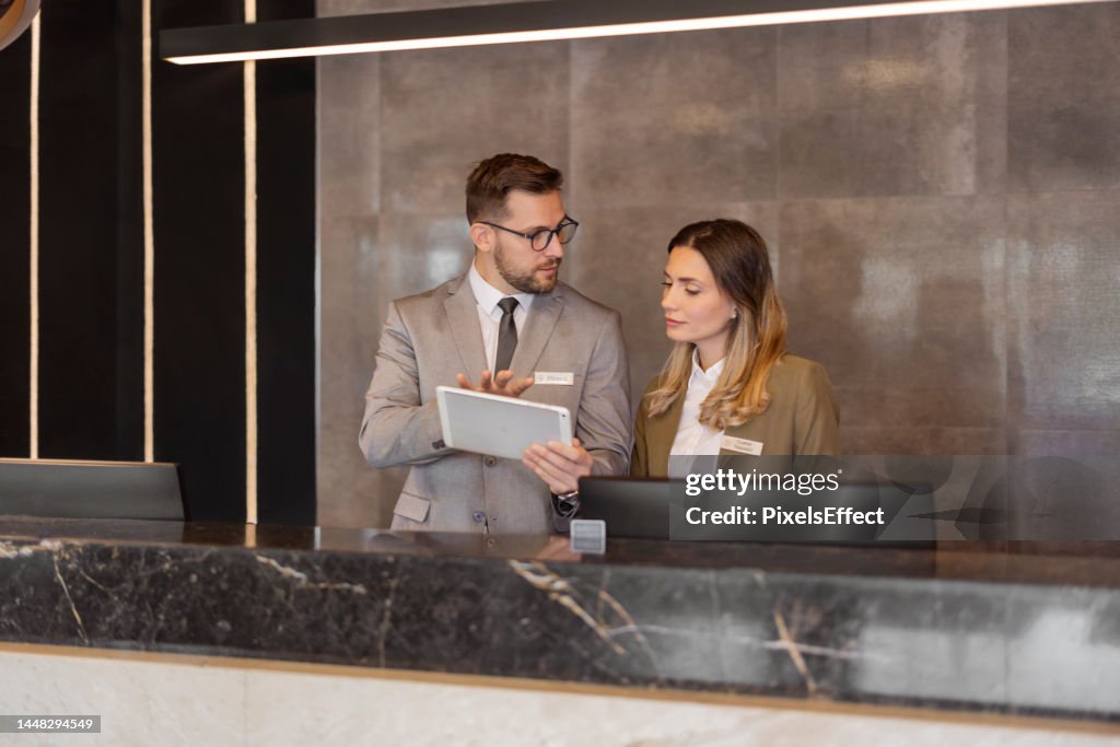 Recepcionistas de hotel usando tableta digital