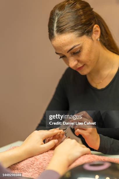 artista de uñas mano creando manicura para el visitante - painting fingernails stock pictures, royalty-free photos & images