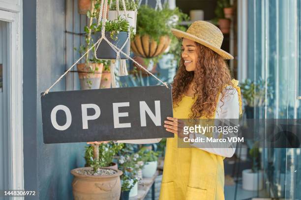 small business, sign and woman at a shop for plants, agriculture and advertising open at a market. marketing, happy and business owner opening a store with flowers, ecology and board at entrance - small placard stock pictures, royalty-free photos & images