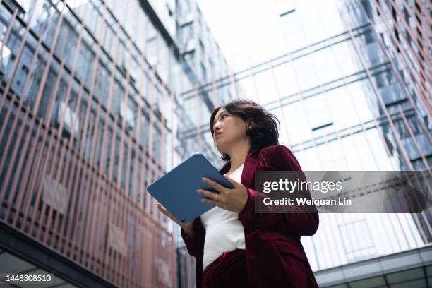 woman using tablet computer downstairs in office - businesswoman under stock-fotos und bilder