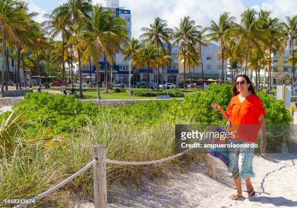 young latin woman enjoying a day trip at the world famous miami beach, south beach, florida, united states of america, usa,  sunlight illuminating at midday on a blue sunny summer day. - jason statham on set of despierta america in miami stockfoto's en -beelden