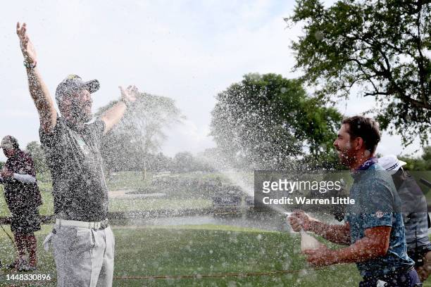 Ockie Strydom of South Africa being sprayed champagne by Erik Van Rooyen of South Africa after winning the Alfred Dunhill Championship on the 18th...