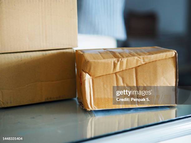 three brown carton box on mirror table, dented box damaged - damaged parcel stock pictures, royalty-free photos & images