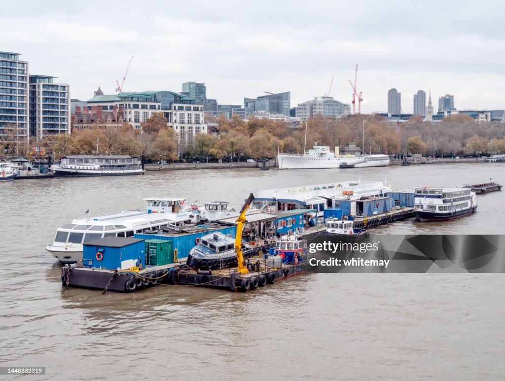 Service barges moored in the River Thames, London