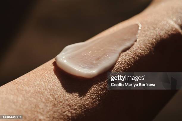 a smear of white moisturizer on the hand. - skin cream photos et images de collection
