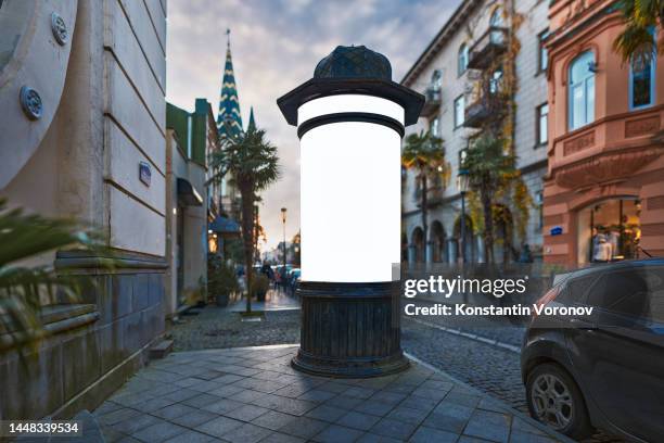 theatre or cinema billboard (colonne morris in french) for placards, retro cylindrical advertising pillar, old-fashioned announcement column mockup. selective focus, blurred background - advertising column - fotografias e filmes do acervo