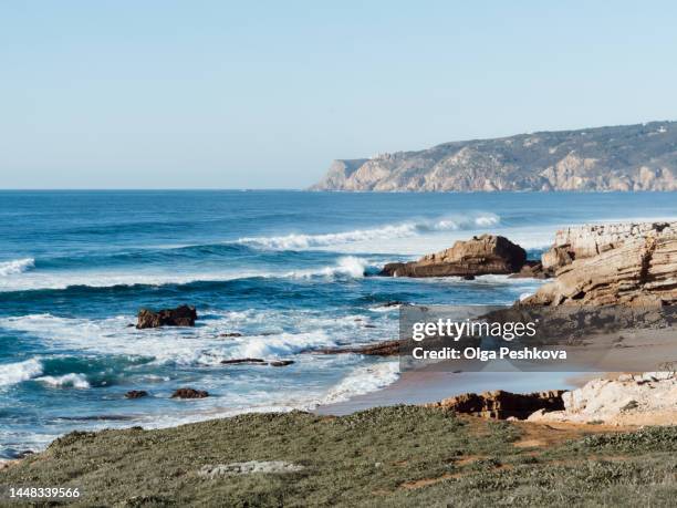 view of atlantic ocean hitting the granite rocks on the coast. rocky environment with amazing color of the ocean - rocky coastline - fotografias e filmes do acervo