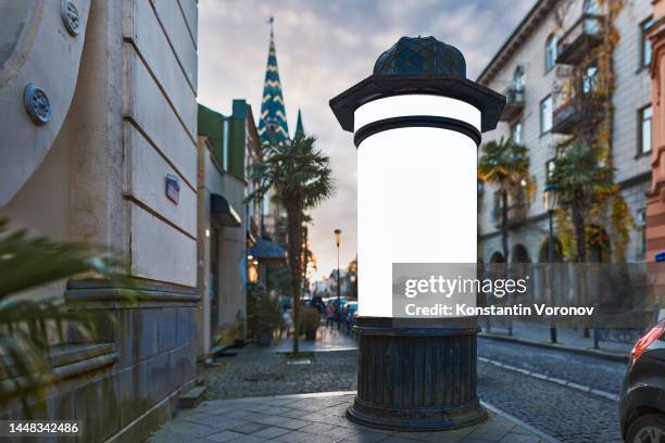 theatre or cinema billboard (colonne morris in french) for placards, retro cylindrical advertising pillar, old-fashioned announcement column mockup. selective focus, blurred background - advertising column stock pictures, royalty-free photos & images