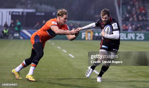 Elliot Daly of Saracens gets away from Duhan van der Merwe to score their first try during the Heineken Cup match between Saracens and Edinburgh at...