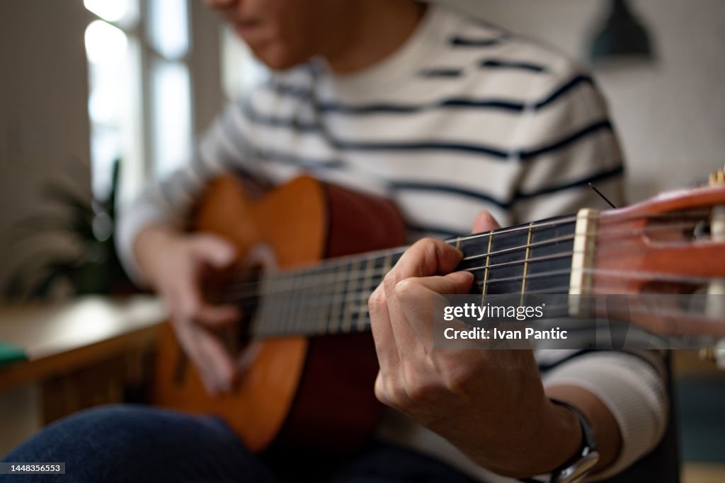 Close up of playing a guitar.