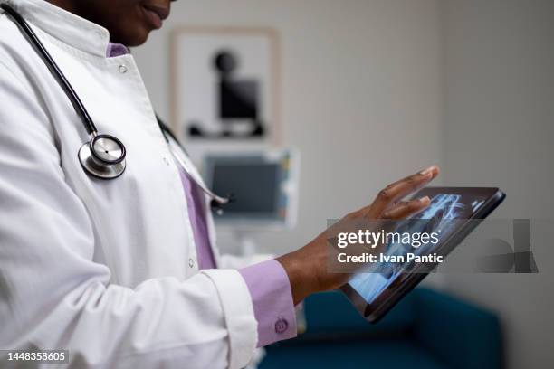 close up of a black doctor examining medical scan on touchpad. - tablet close up real copyspace stock pictures, royalty-free photos & images