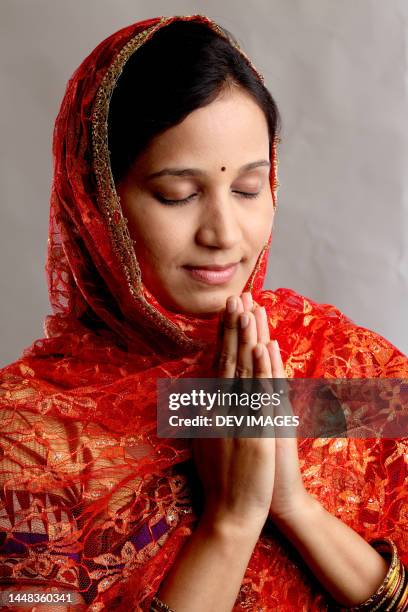 young indian woman with hands in prayer position - namaste greeting stock pictures, royalty-free photos & images