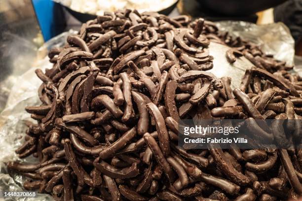 Chocolate-covered orange peels among typical Sicilian sweets at the Christmas market set up in Piazza Università on December 11, 2022 in Catania,...