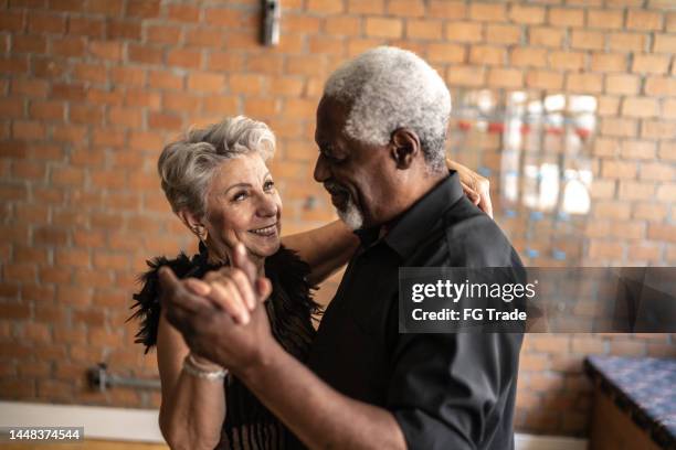 senior couple dancing waltz in dance hall - older couple ballroom dancing stock pictures, royalty-free photos & images