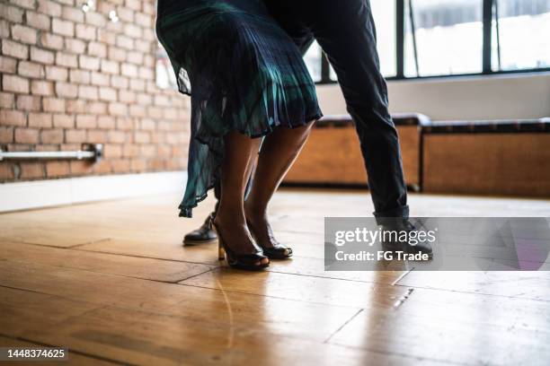 low-section of senior couple practicing steps in the dance hall - ballroom stockfoto's en -beelden