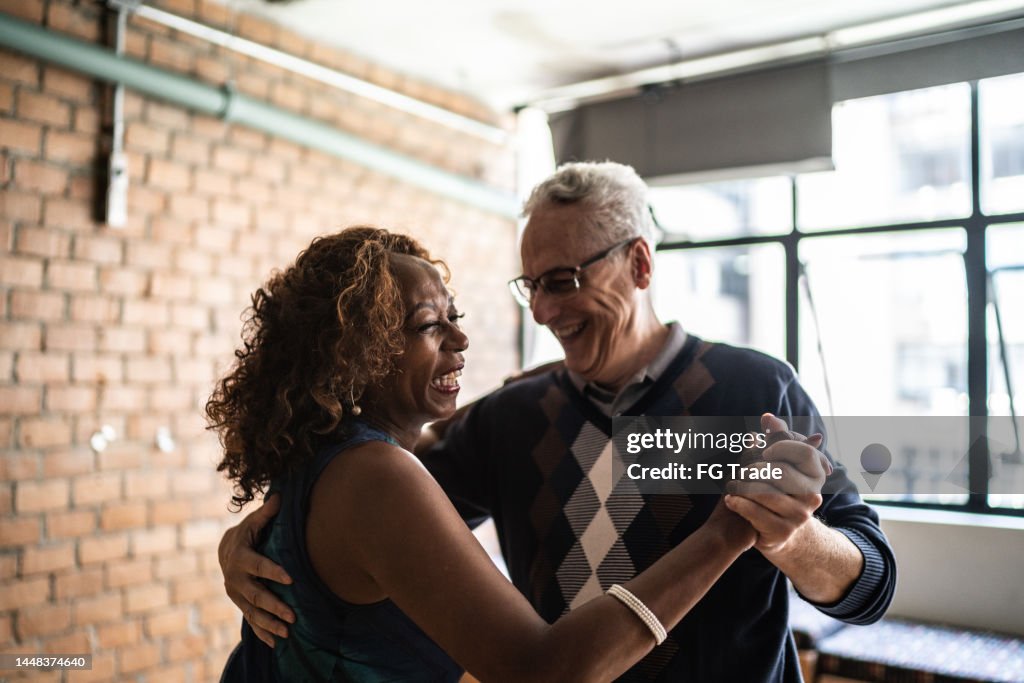 Senior couple dancing waltz in dance hall
