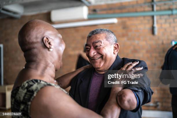 amputee mature man dancing with his wife in dance hall - active seniors dancing stock pictures, royalty-free photos & images