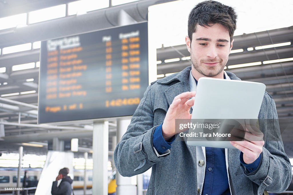 Man with digital tablet at train station