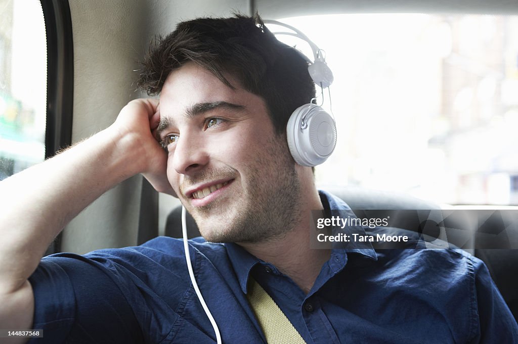 Man smiling in taxi with headphones