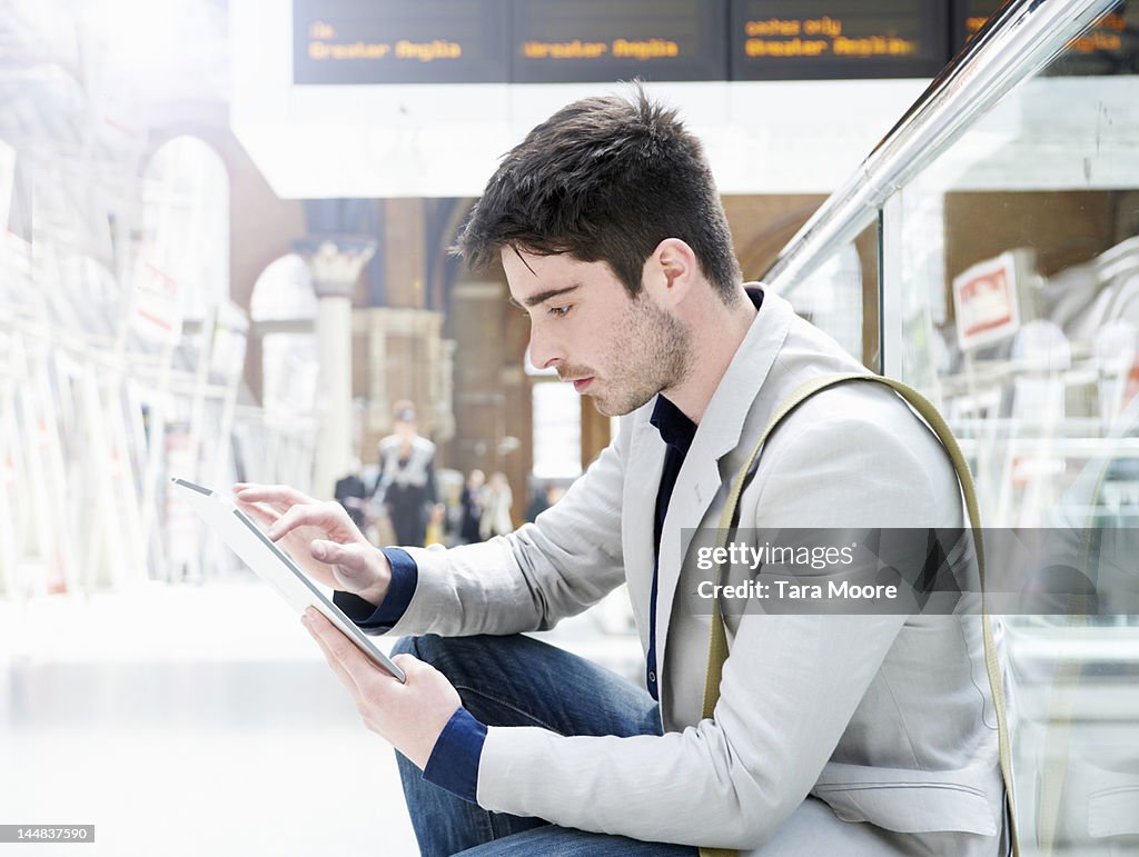 Man with digital tablet at train station