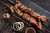 Kebabs grilled meat skewers, shish kebab, on old dark wooden table background