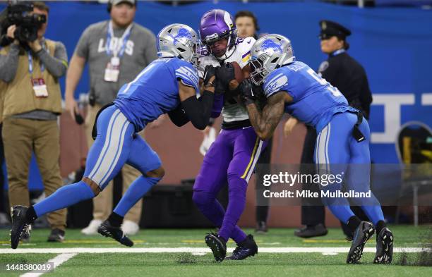 Justin Jefferson of the Minnesota Vikings is tackled by Jeff Okudah and DeShon Elliott of the Detroit Lions during the second quarter at Ford Field...