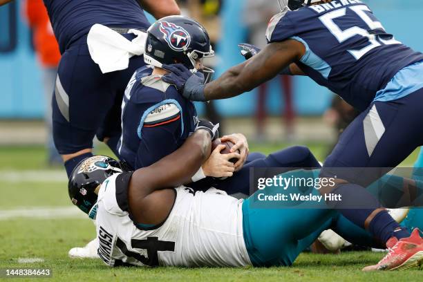 Ryan Tannehill of the Tennessee Titans is sacked by Folorunso Fatukasi of the Jacksonville Jaguars in the third quarter of the game at Nissan Stadium...