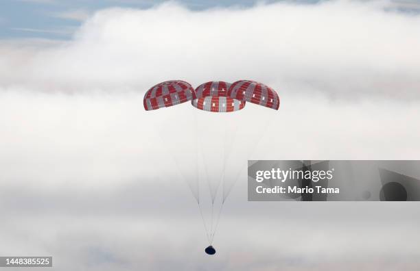 S Orion Capsule descends toward splash down after a successful uncrewed Artemis I Moon Mission on December 11, 2022 seen from aboard the U.S.S....