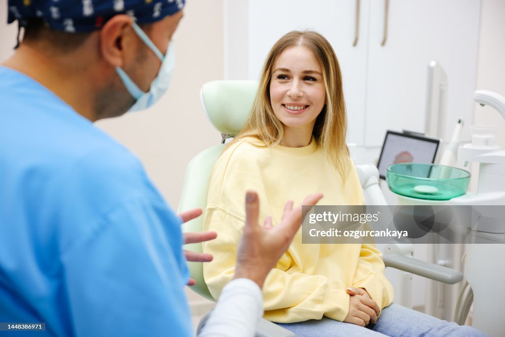 Blonde female patient sitting on dentist chair and smiling
