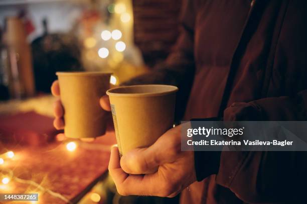 men's hands holding mulled wine at the christmas market - bowle stock-fotos und bilder